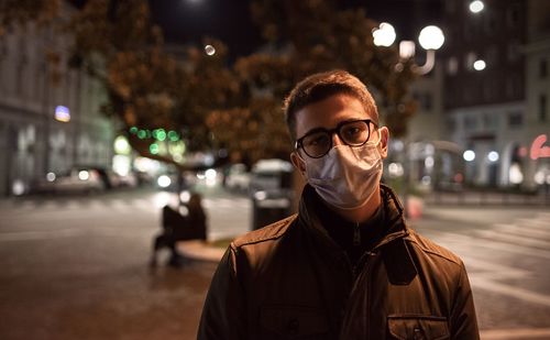 Portrait of young man standing on street at night in italy under the covid period 