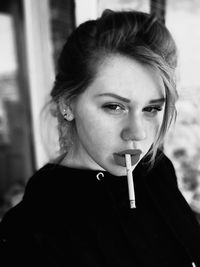 Portrait of young woman smoking cigarette outdoors