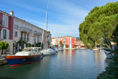 Boats moored at harbor against sky