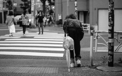 Rear view of people walking on road