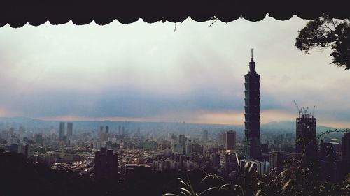 Skyscrapers in city at sunset