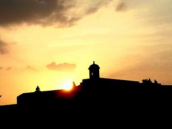 Low angle view of silhouette built structure against sky at sunset