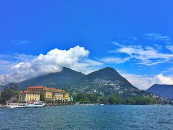 Scenic view of lake and mountains against blue sky