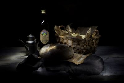 Close-up of fruits in basket on table against black background