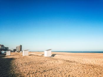 Scenic view of beach against clear blue sky