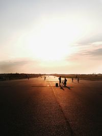 Friends with bicycle on road against sky