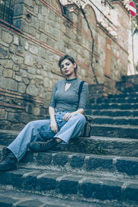Young woman sitting on staircase