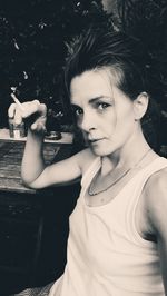 Portrait of woman smoking cigarette at table