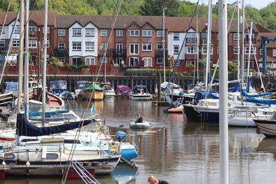 Boats moored in canal by houses