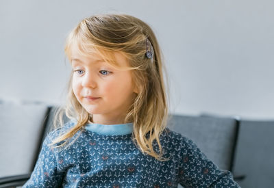 Cute baby girl looking away while looking away at home