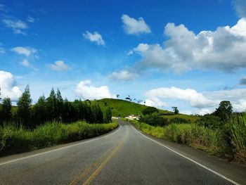 Road amidst trees against sky