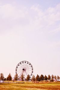 Ferris wheel on field against sky