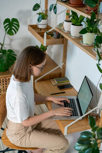 Young woman working on laptop from home.