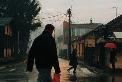 Rear view of man walking on street in town