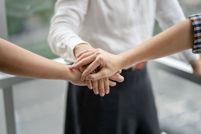 Cropped image of friends stacking hands