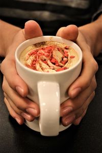 Cropped hands of teenage boy having coffee at table