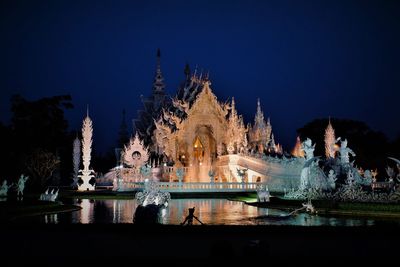 Illuminated temple building against sky at night