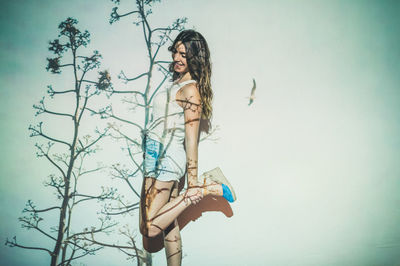 Side view of woman standing against sky