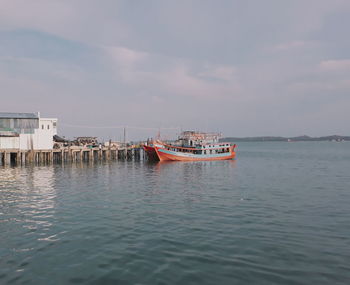 Boat moored in sea against sky