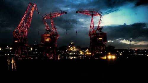 Low angle view of crane against cloudy sky