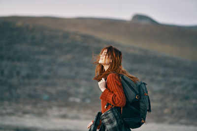 Side view of woman standing against blurred background