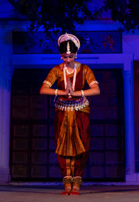 Portrait of woman with umbrella standing at night