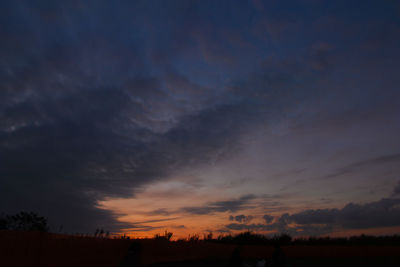 Scenic view of silhouette field against sky at sunset