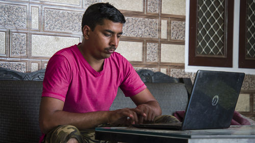 Young man using mobile phone at home