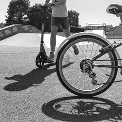 Low section of woman with bicycle on road