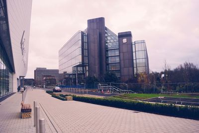 Buildings in city against cloudy sky