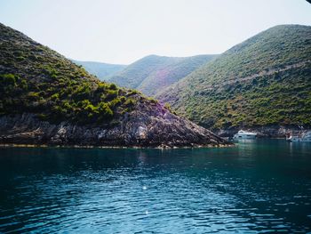 Scenic view of lake by mountains against sky