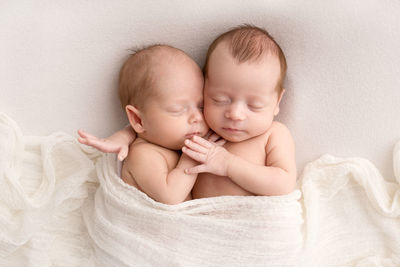 Portrait of cute baby boy lying on bed at home