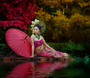 Reflection of young woman in lake