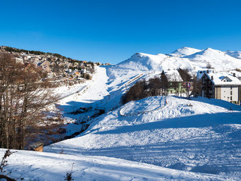 Scenic view of snowcapped mountains against clear blue sky