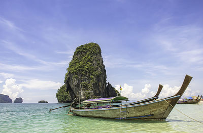 Lots of boat tours and tourists on beach background island at phra nang cave beach , krabi, thailand