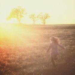 People standing on field at sunset