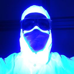 Portrait of young man wearing mask against blue background