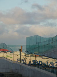 Low angle view of glass walkway reflecting image of ferry on the mersey river