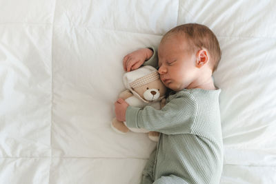 Portrait of cute baby girl sleeping on bed at home