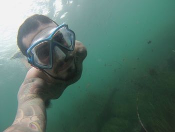 Portrait of shirtless man swimming in sea