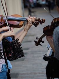 Midsection of people playing violins