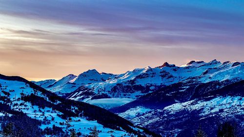 Scenic view of snowcapped mountains against sky during sunset