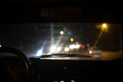 Close-up of illuminated car on windshield at night