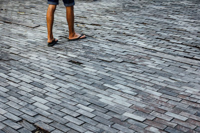 Low section of woman on cobblestone