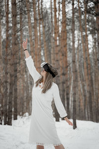 Woman wearing virtual reality simulator against trees outdoors