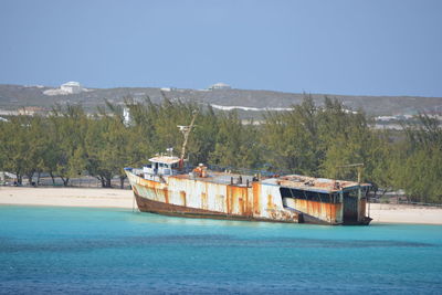 View of obsolete ship near beach against clear sky