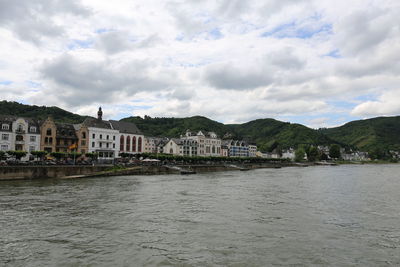 River by buildings in city against sky