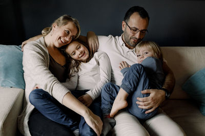 Happy loving family sitting together on couch at home