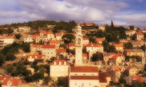 View of cityscape against cloudy sky