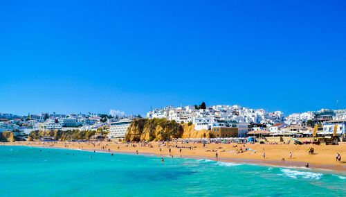 Panoramic view of sea and buildings against blue sky